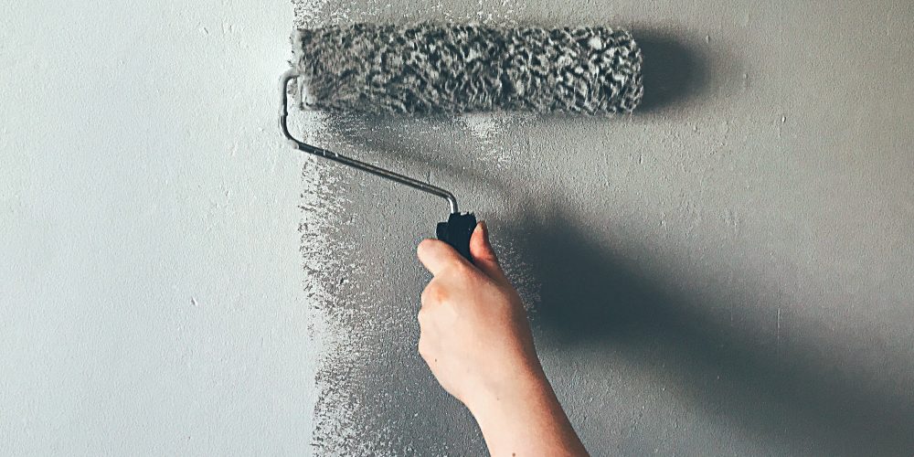 Woman painting wall with paint roller